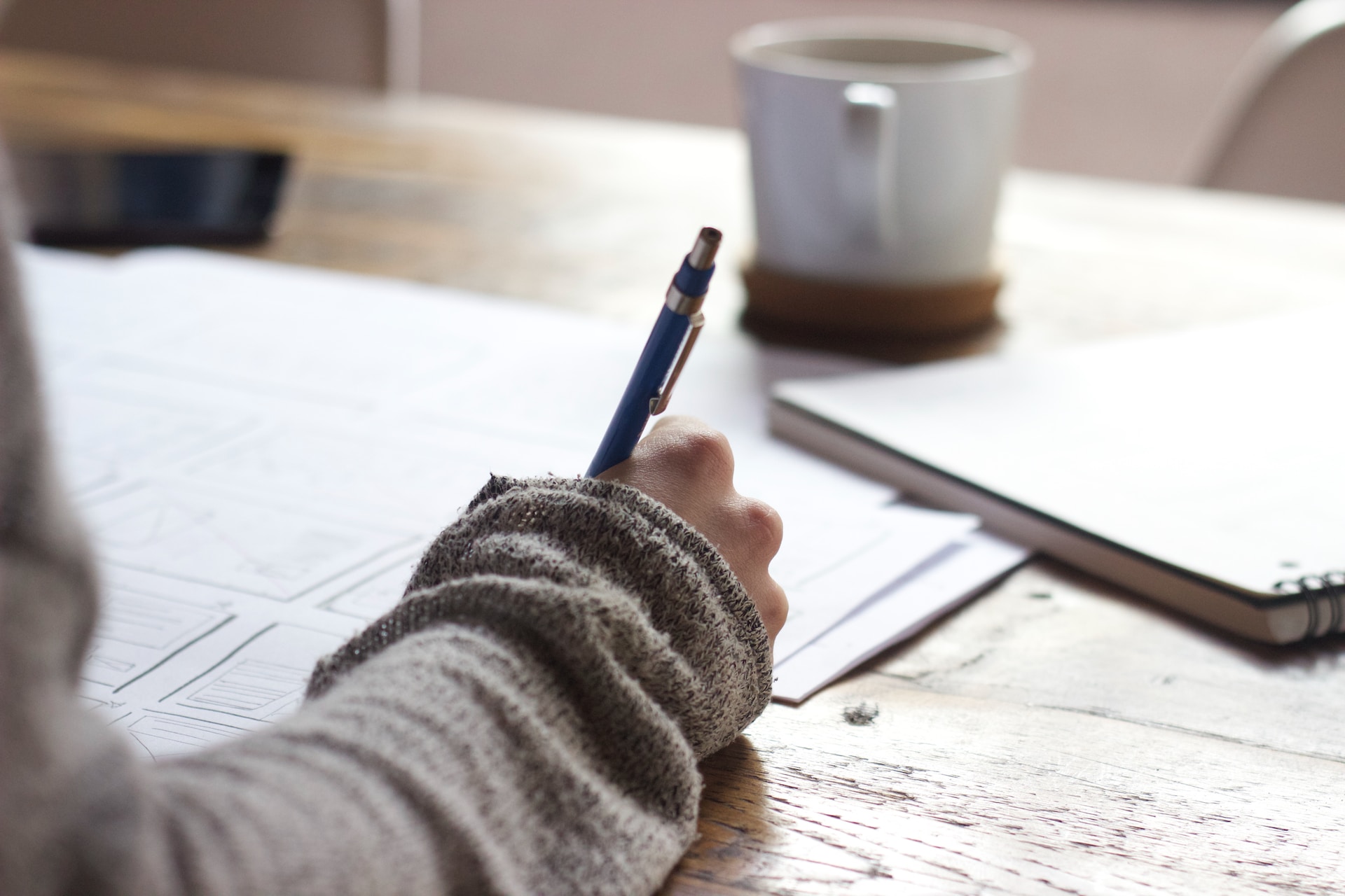 Woman writing notes and sketching website wireframes