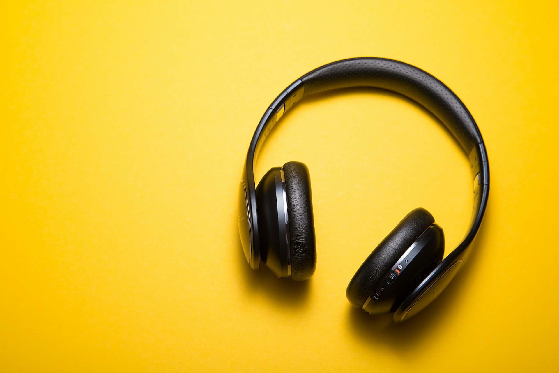 a pair of headphone laying on a yellow background